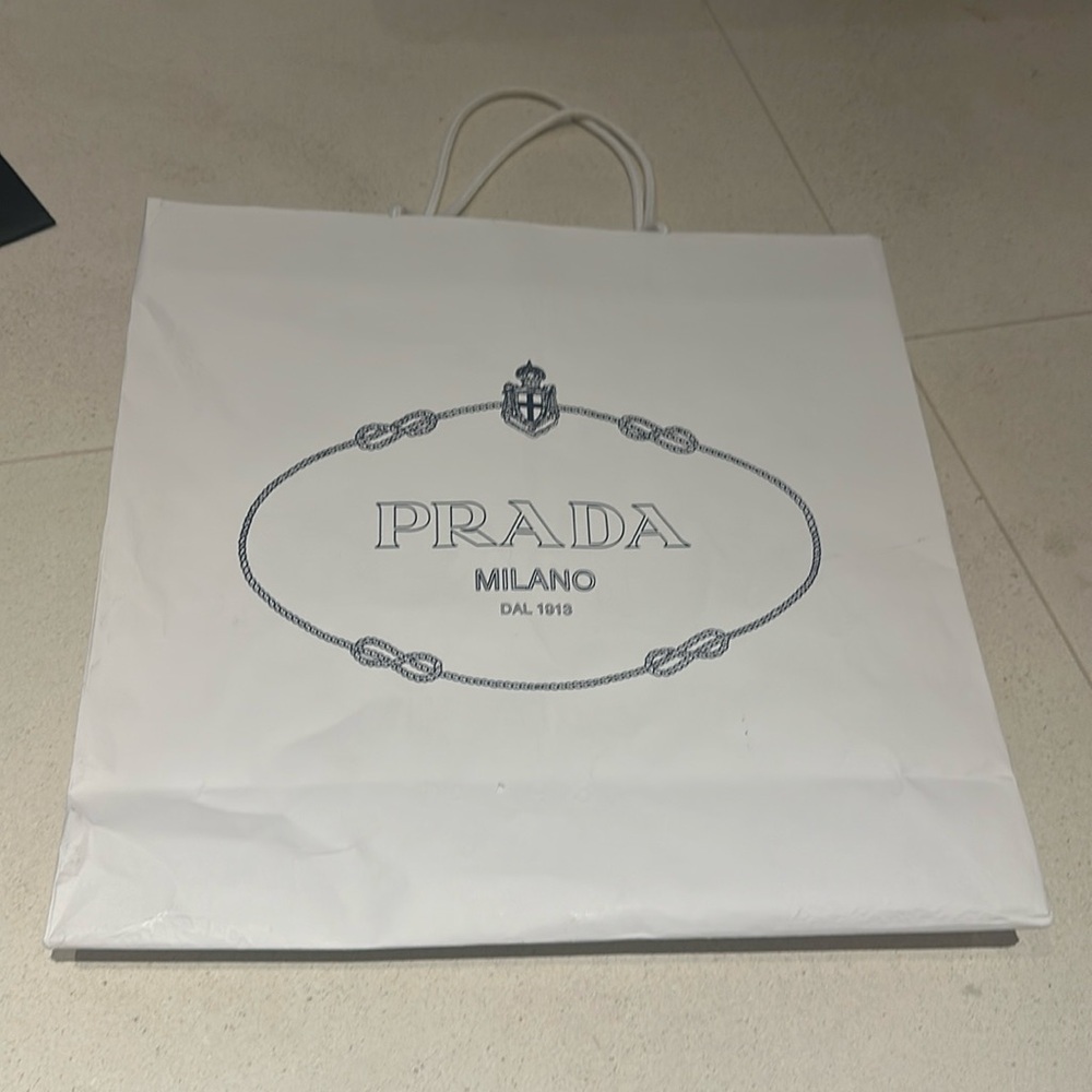 Two Prada medium and large sized paper bags.